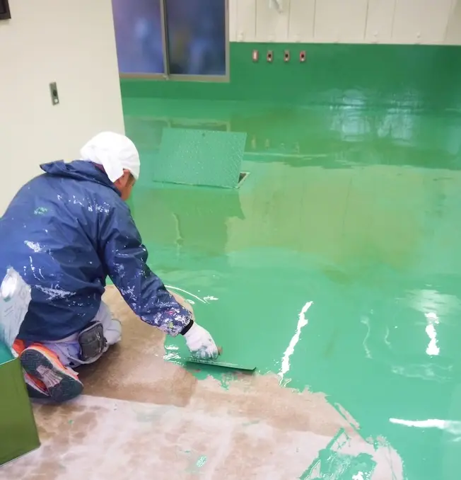 ローラーで丁寧に壁面に塗布される様子。