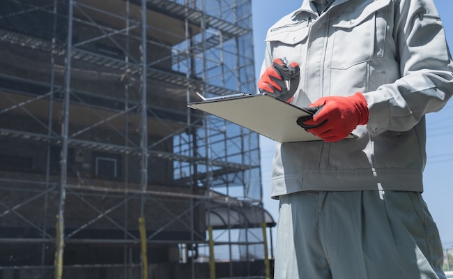 修繕工事の足場と作業服の男性